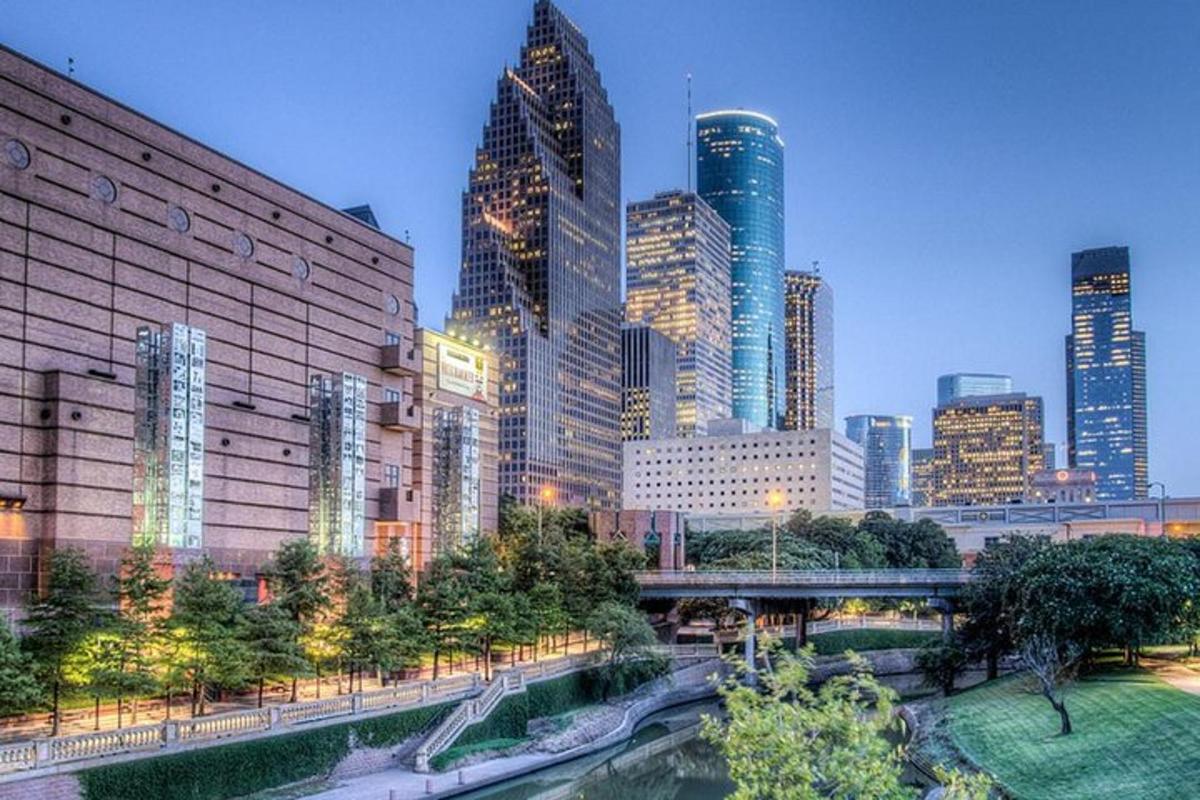 a city skyline with tall buildings and a river