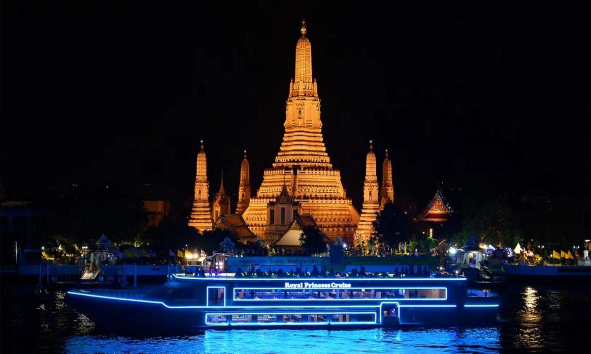a boat in front of a large building at night