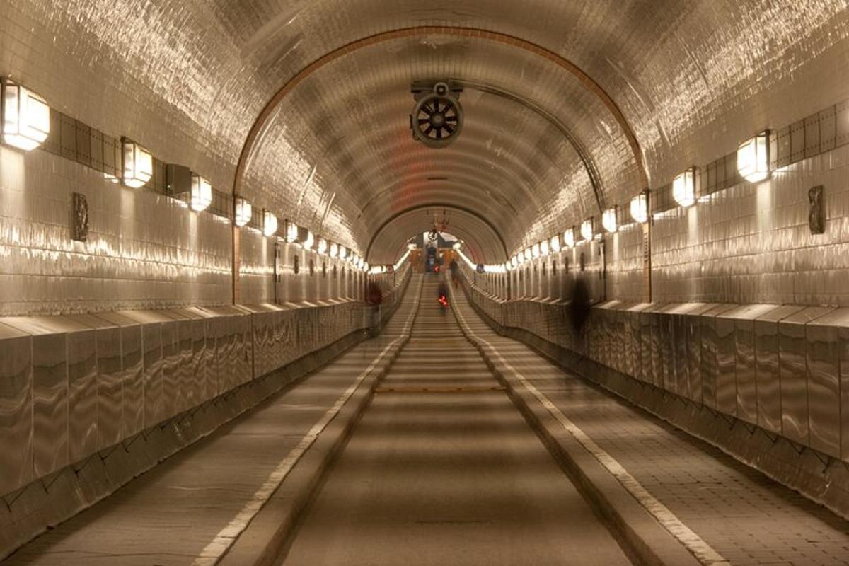 Un largo pasillo en un túnel con una persona caminando por él.
