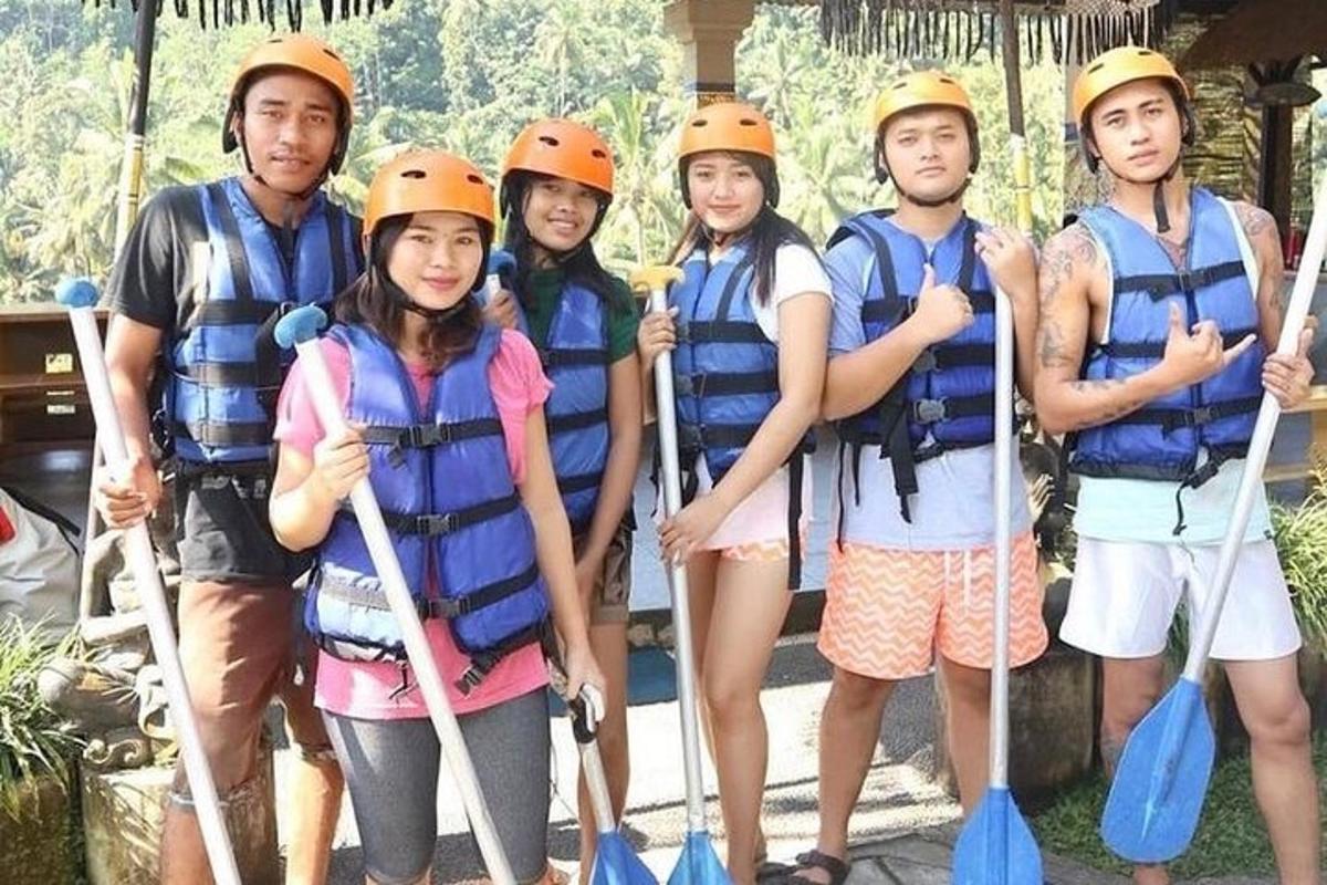 a group of people in helmets standing on a raft