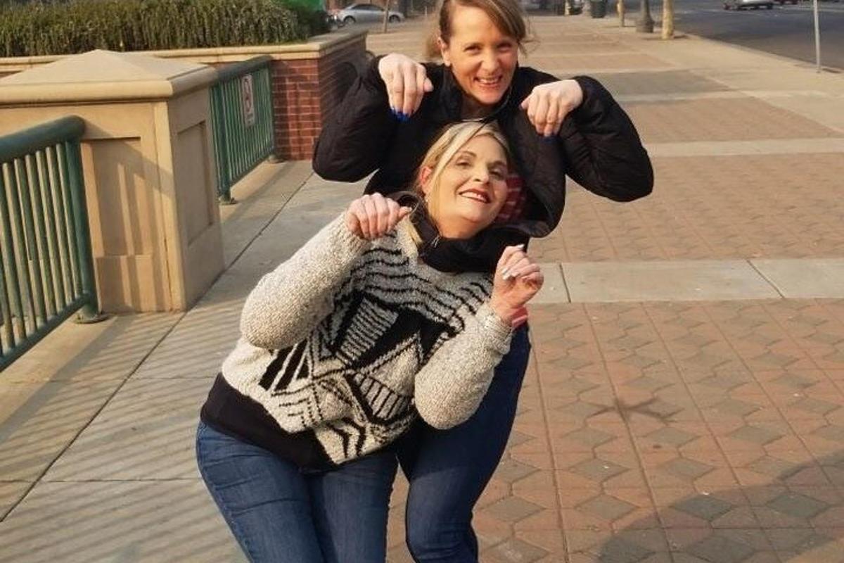 due ragazze posano per una foto su un marciapiede