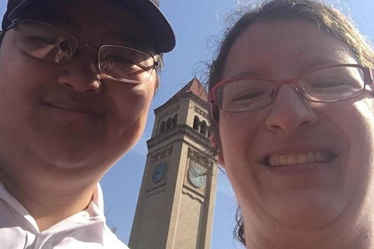 a man and a woman standing in front of a clock tower