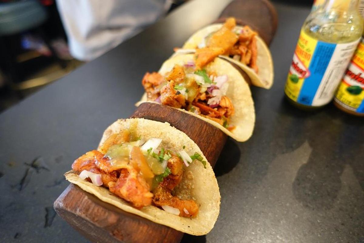 pár tacos na stole vedle lahví
