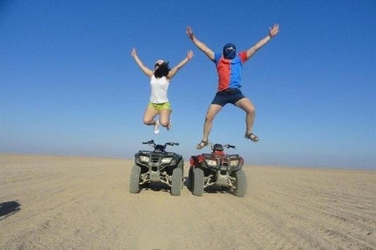 due persone che saltano in aria accanto a un camion nel deserto