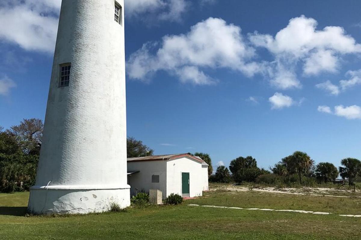 ein Leuchtturm auf einem Feld mit einem Gebäude daneben
