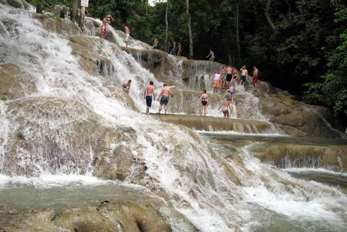 eine Gruppe von Menschen steht am Rand eines Wasserfalls