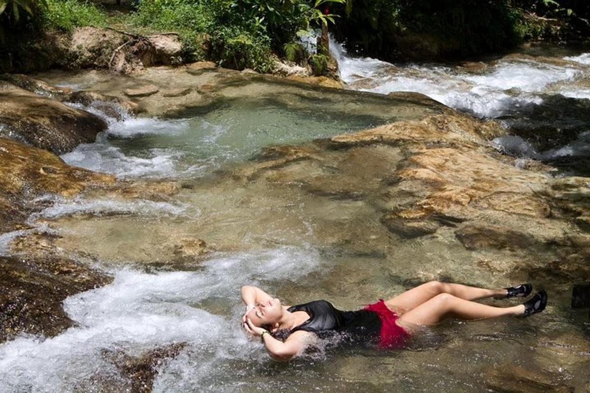 eine Frau, die auf den Felsen in einem Bach liegt