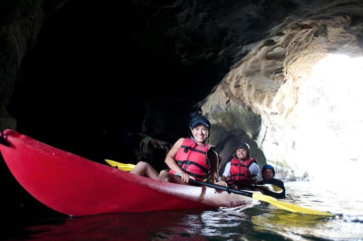a group of people in a red kayak in a cave