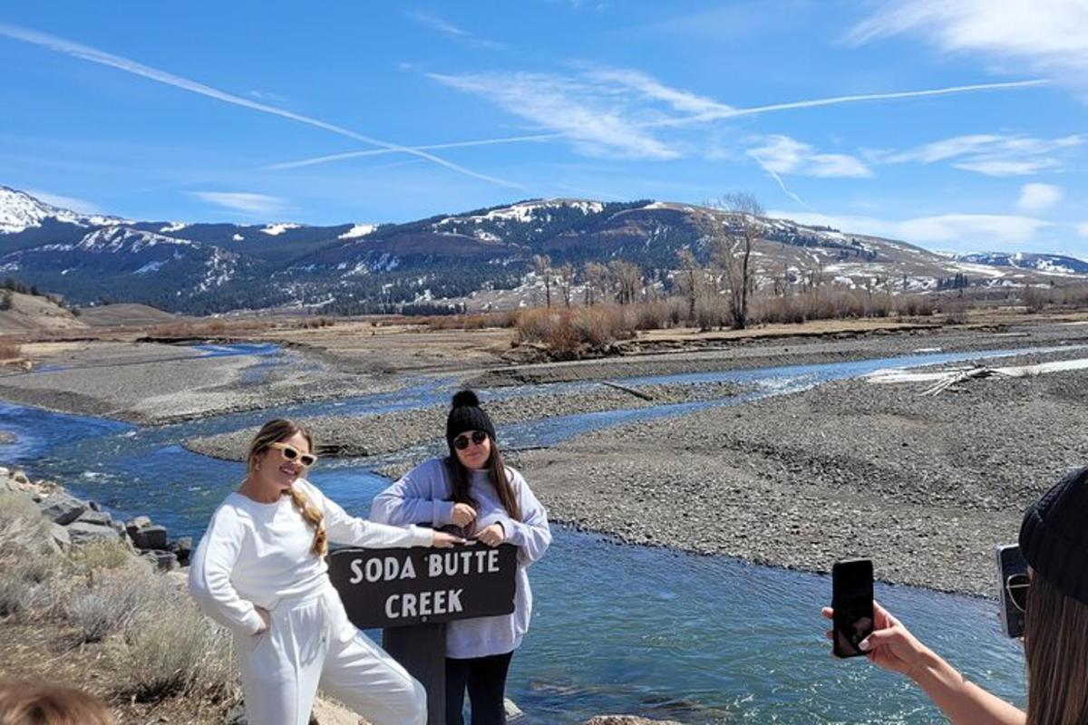 two women holding a sign next to a river