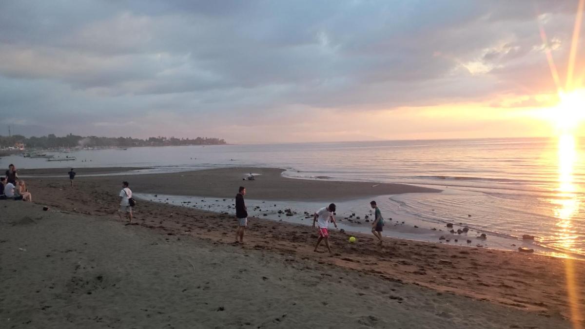 um grupo de pessoas na praia ao pôr do sol