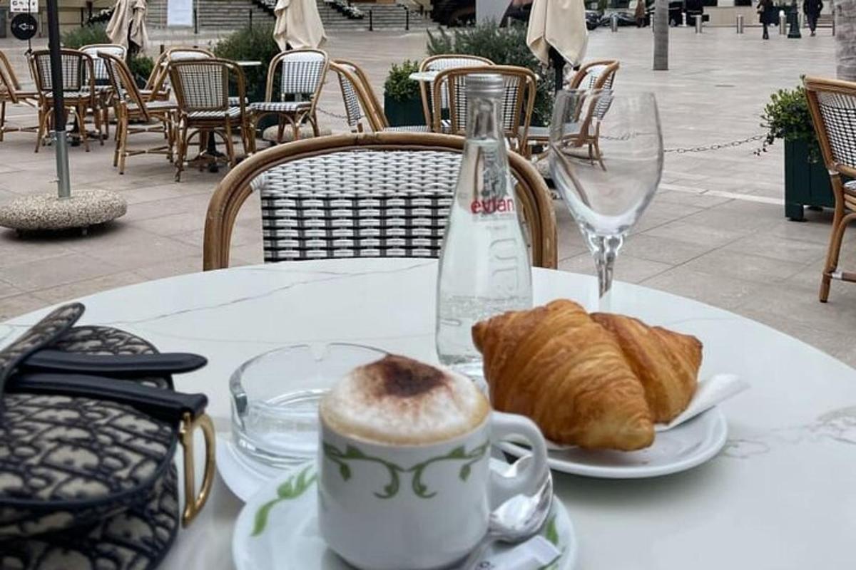 Una mesa con una taza de café y un plato de croissants