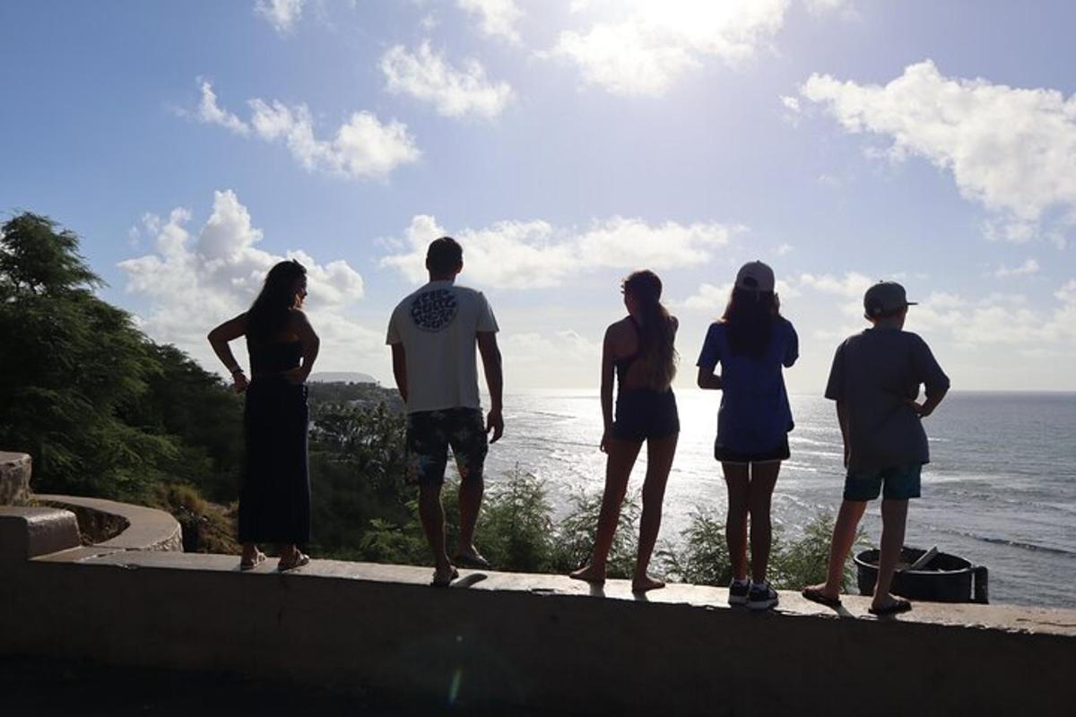 um grupo de pessoas em pé em uma saliência olhando para o oceano