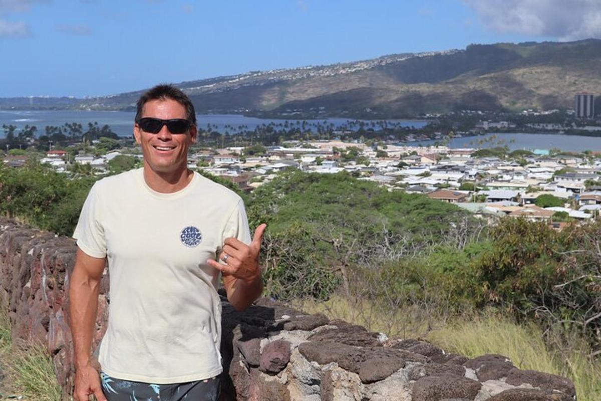 um homem fazendo sinal de positivo enquanto está em cima de um muro