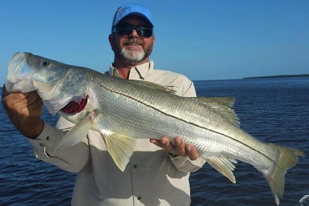 a man holding a large fish in the water