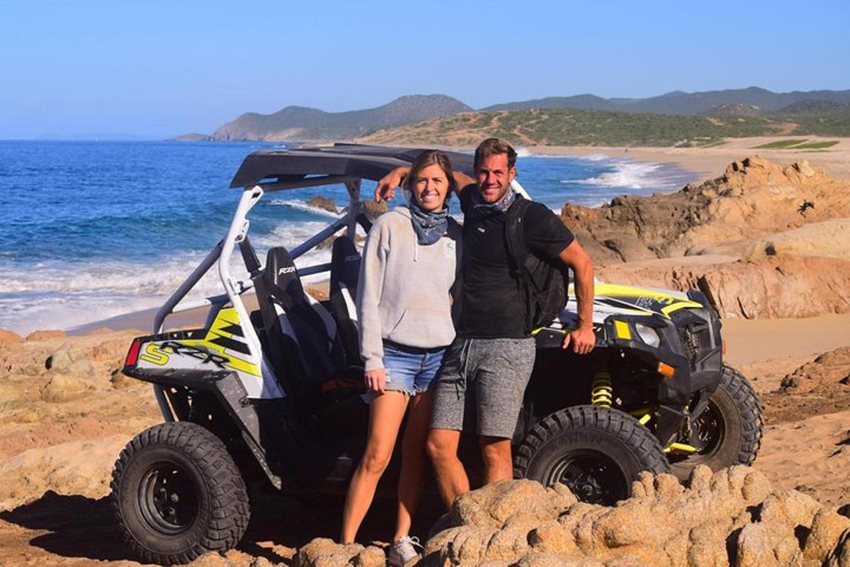 seorang lelaki dan wanita berdiri di sebelah atv di pantai