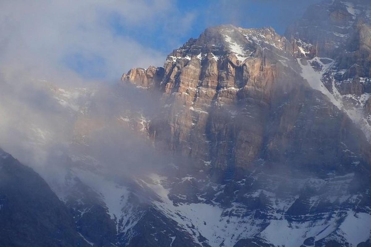 an aerial view of a mountain with snow and clouds