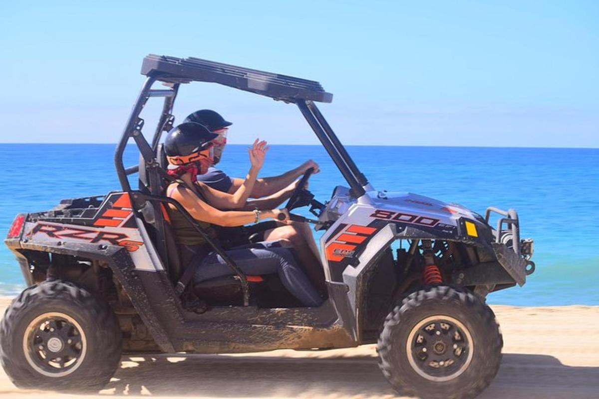 seorang lelaki menunggang basikal quad di pantai