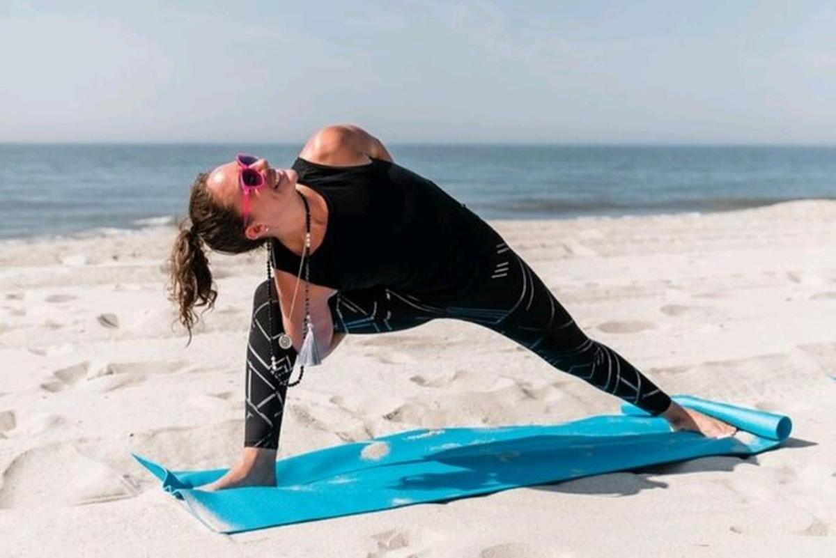a woman standing on a surfboard on the beach