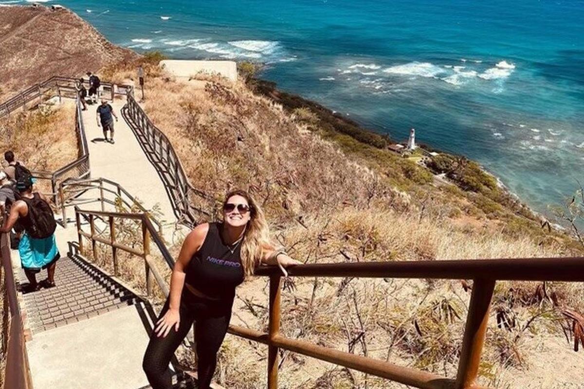 a woman is standing on a staircase near the ocean