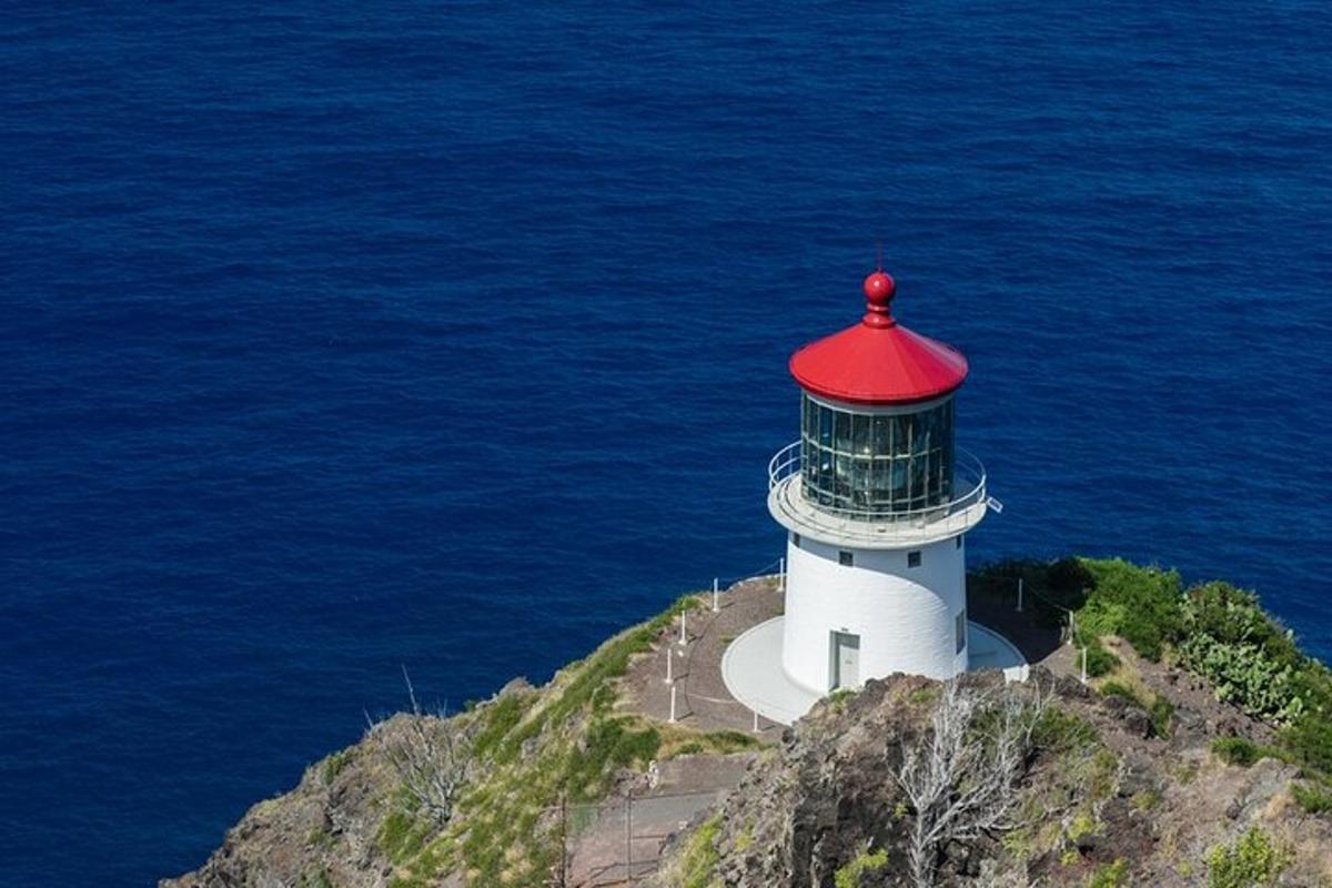 a lighthouse with a red roof on top of the ocean