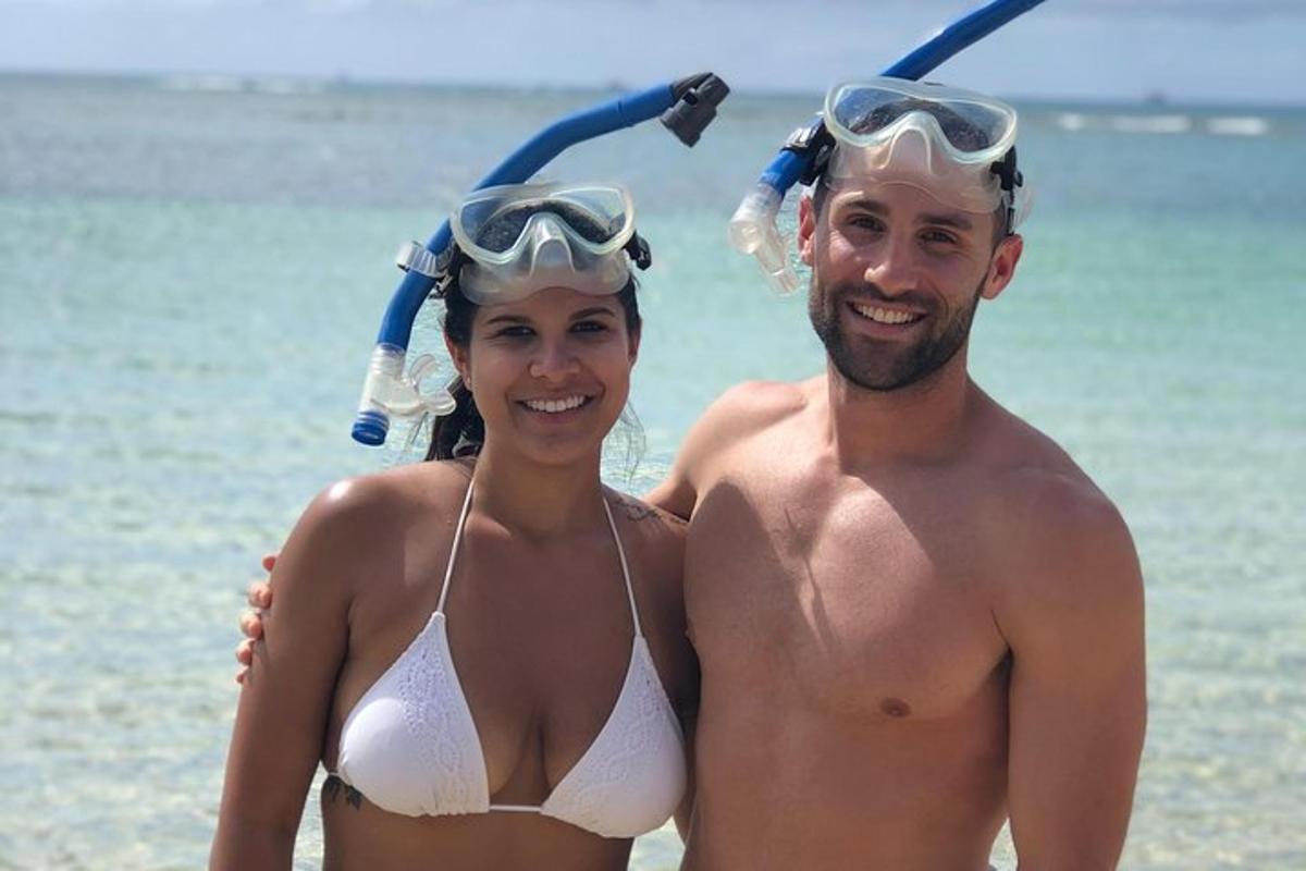 a man and a woman in bathing suits on the beach