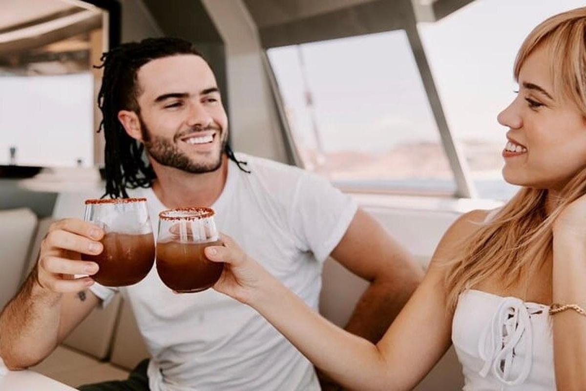 Un hombre y una mujer sosteniendo vasos de cerveza