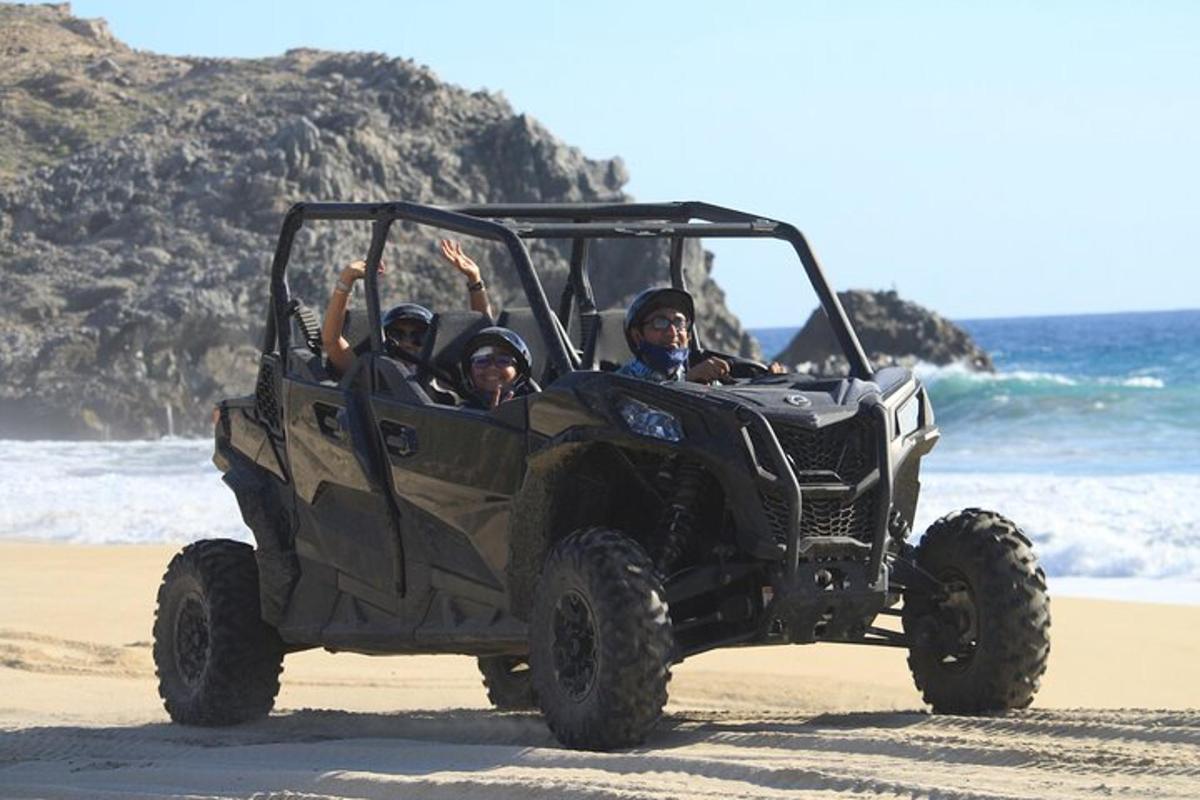a group of people in a jeep on the beach