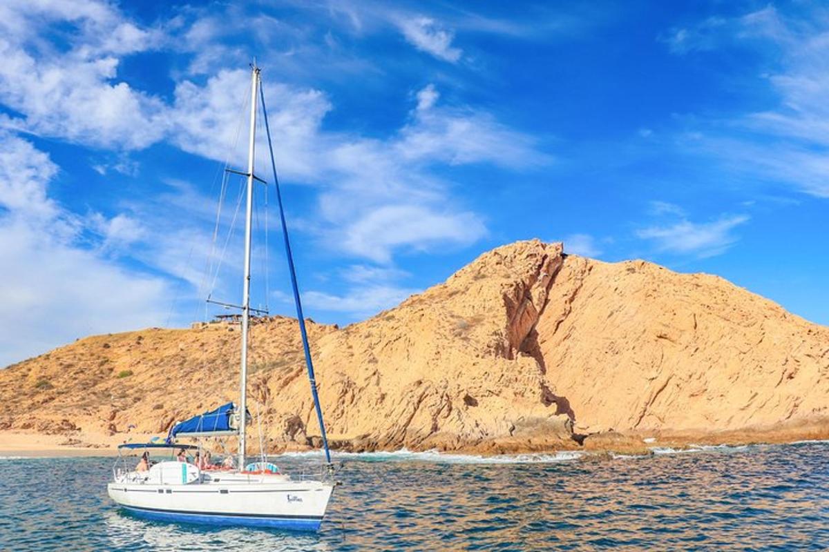 una barca a vela in acqua accanto a un'isola