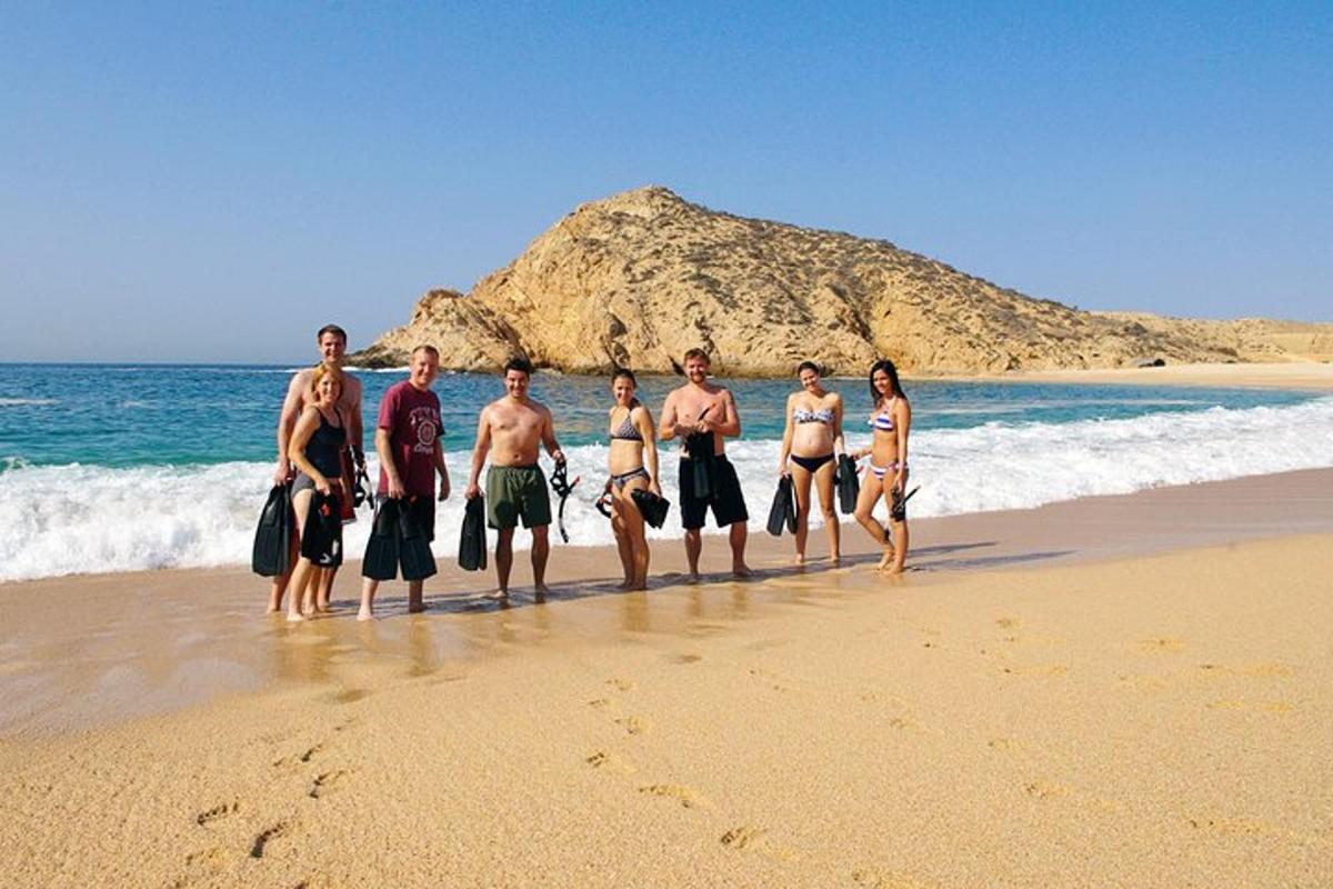sekumpulan lelaki dan wanita berdiri di pantai