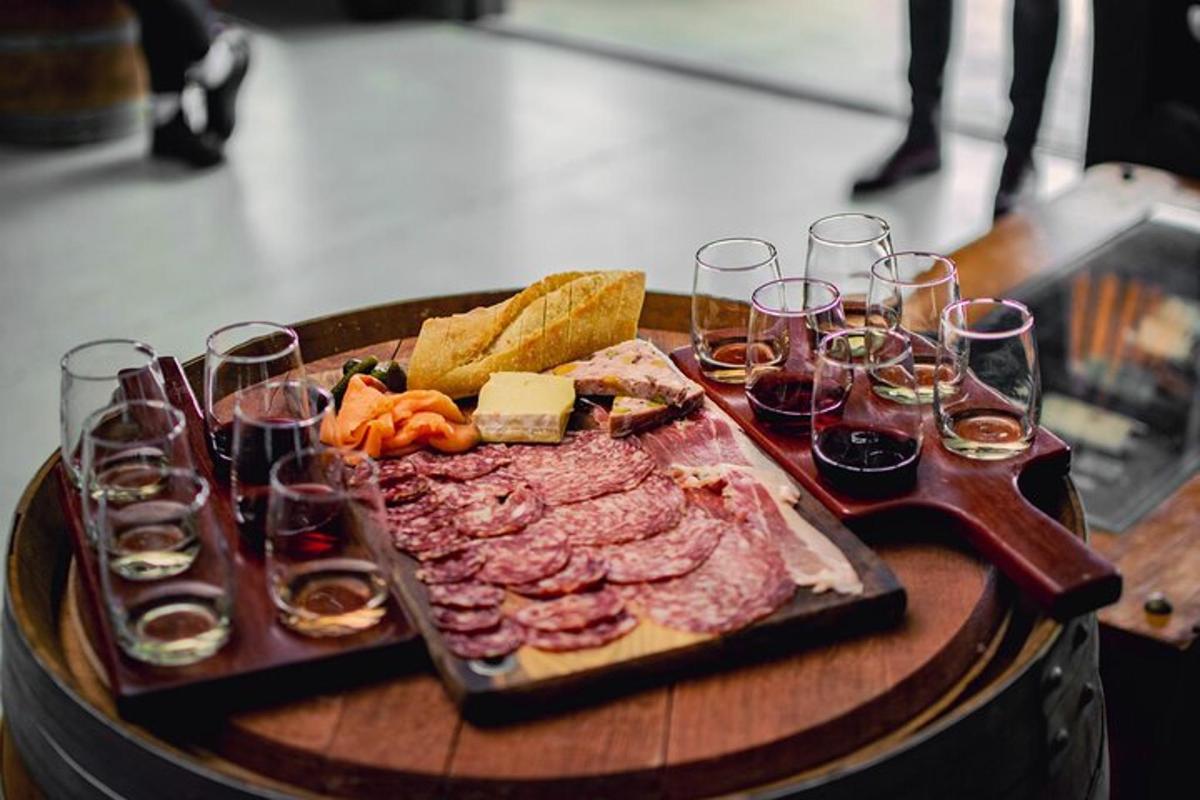 a table with a tray of meat and glasses of wine