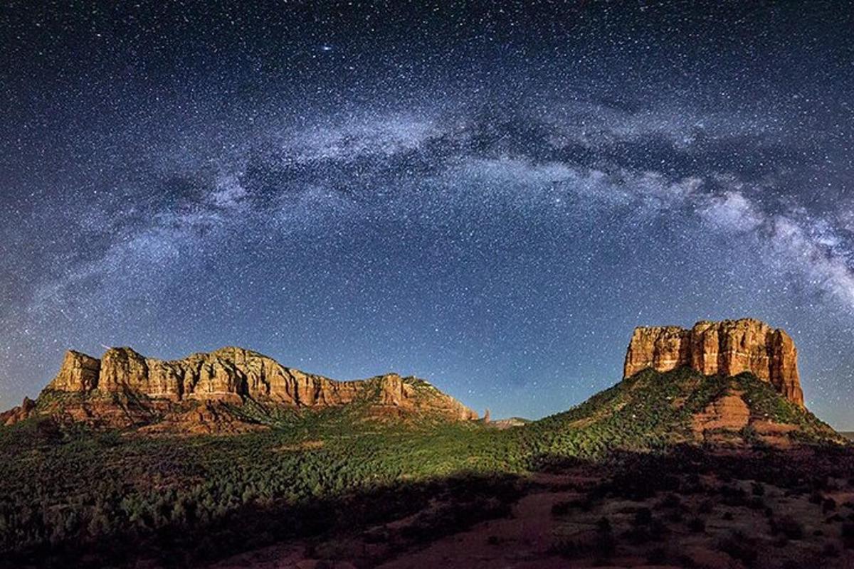 a starry night with a milky way over a mountain
