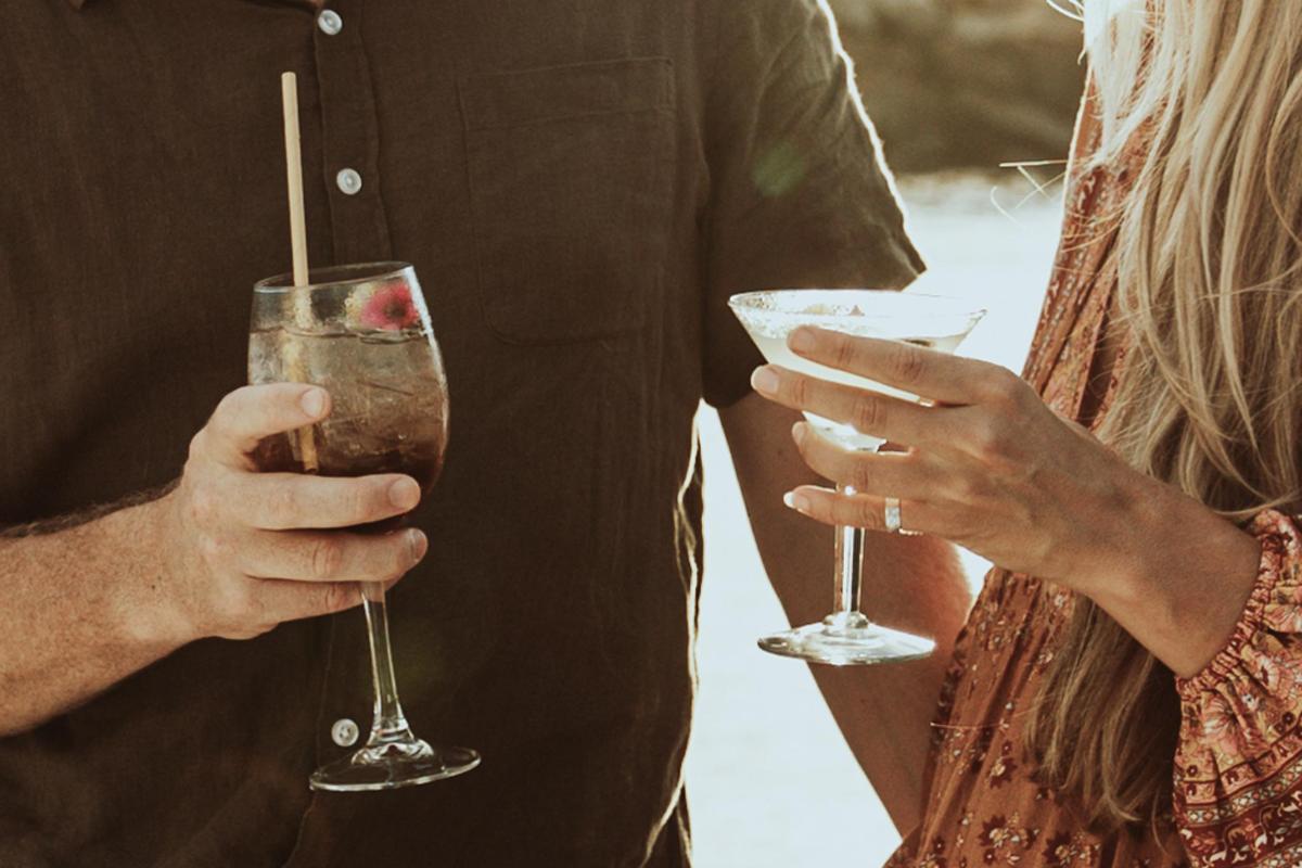 Un hombre y una mujer sosteniendo bebidas en sus manos.