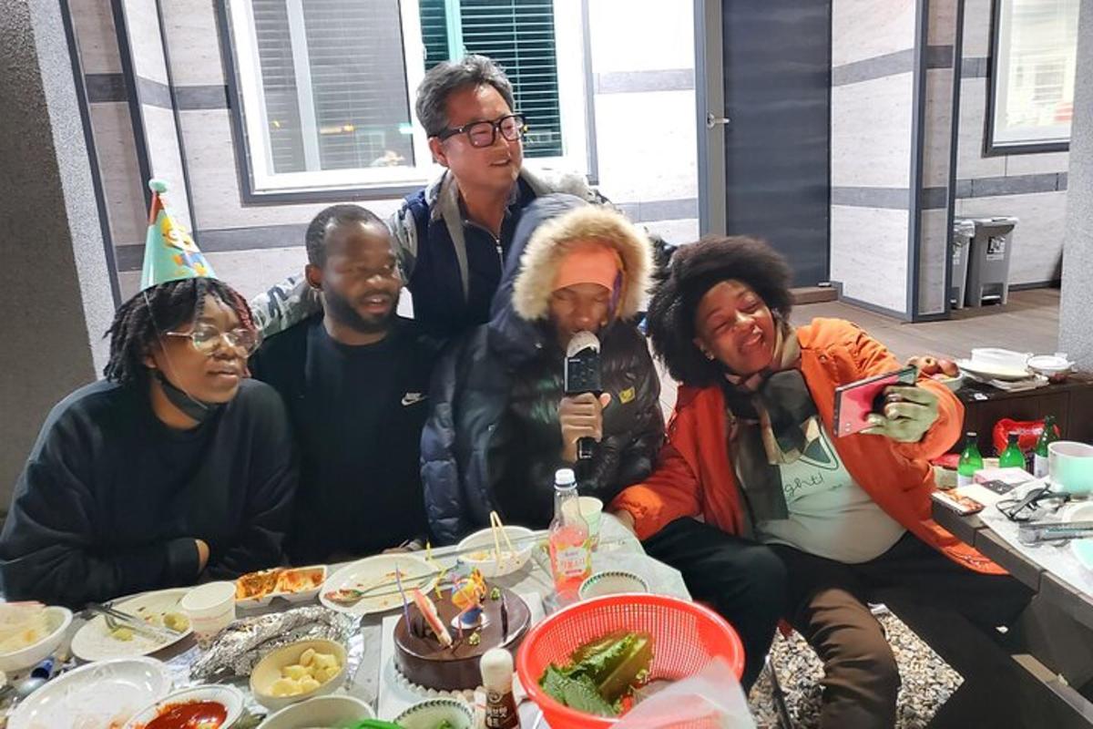 a group of people sitting at a table with food