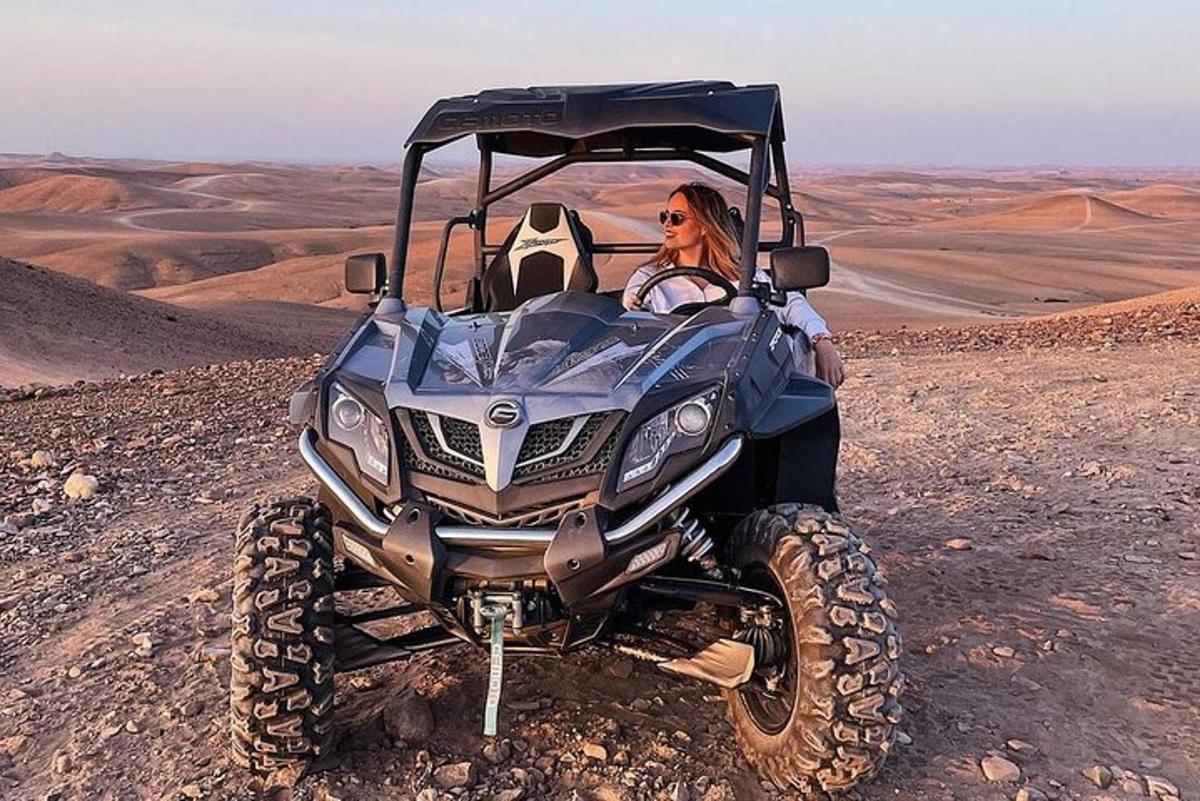 seorang wanita duduk di atv di padang pasir