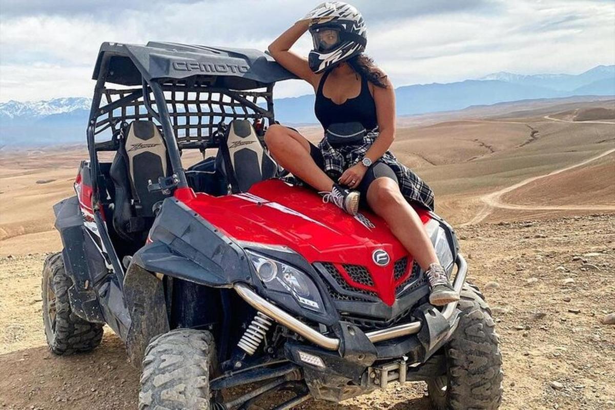 seorang wanita duduk di belakang atv di padang pasir