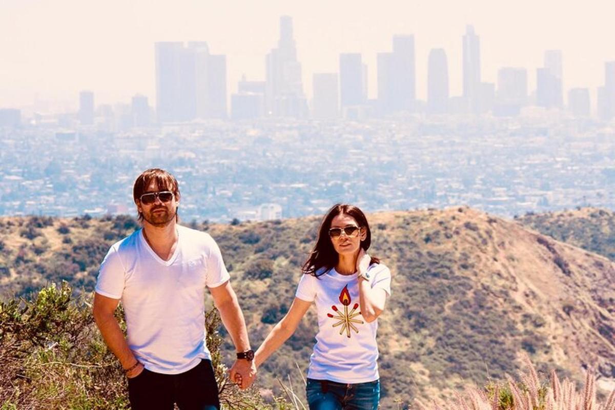 a man and a woman standing on top of a mountain