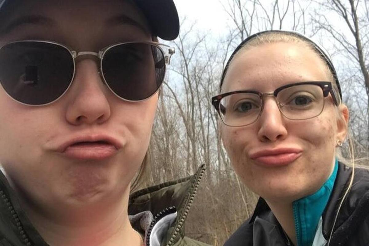 two people wearing glasses standing next to each other