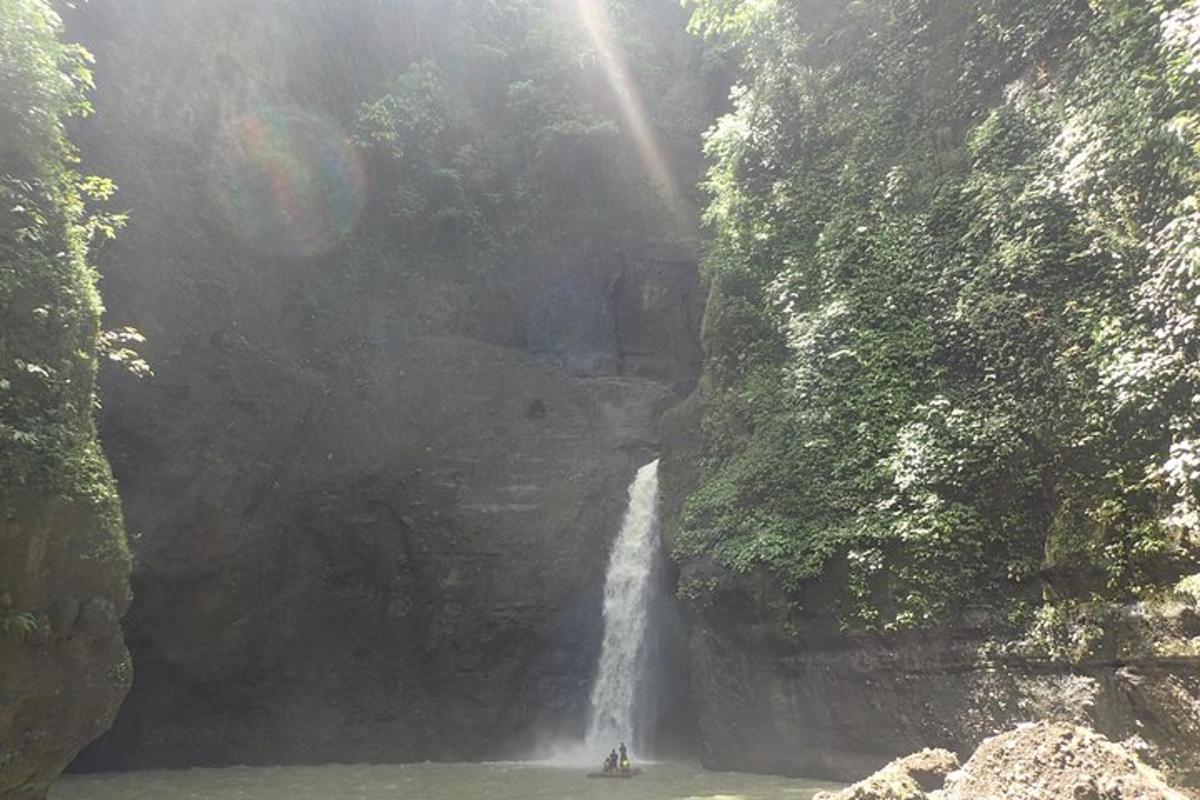 o cascadă în mijlocul unui munte cu o barcă în apă
