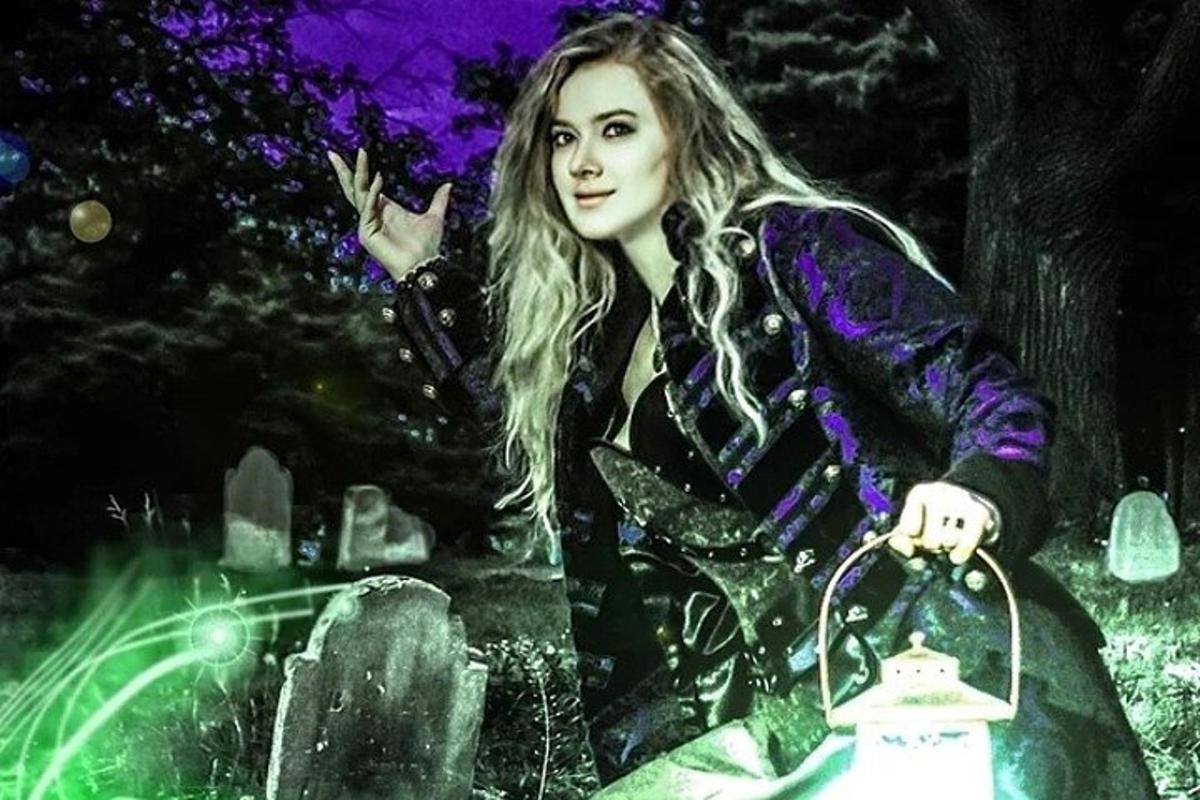 a woman is sitting at a cemetery at night