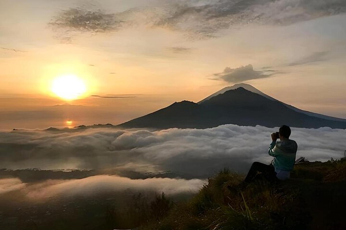 a man taking a picture of a mountain with a camera