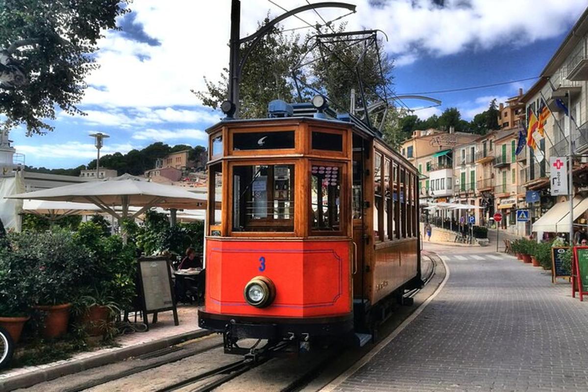 a red trolley car on the tracks on a street