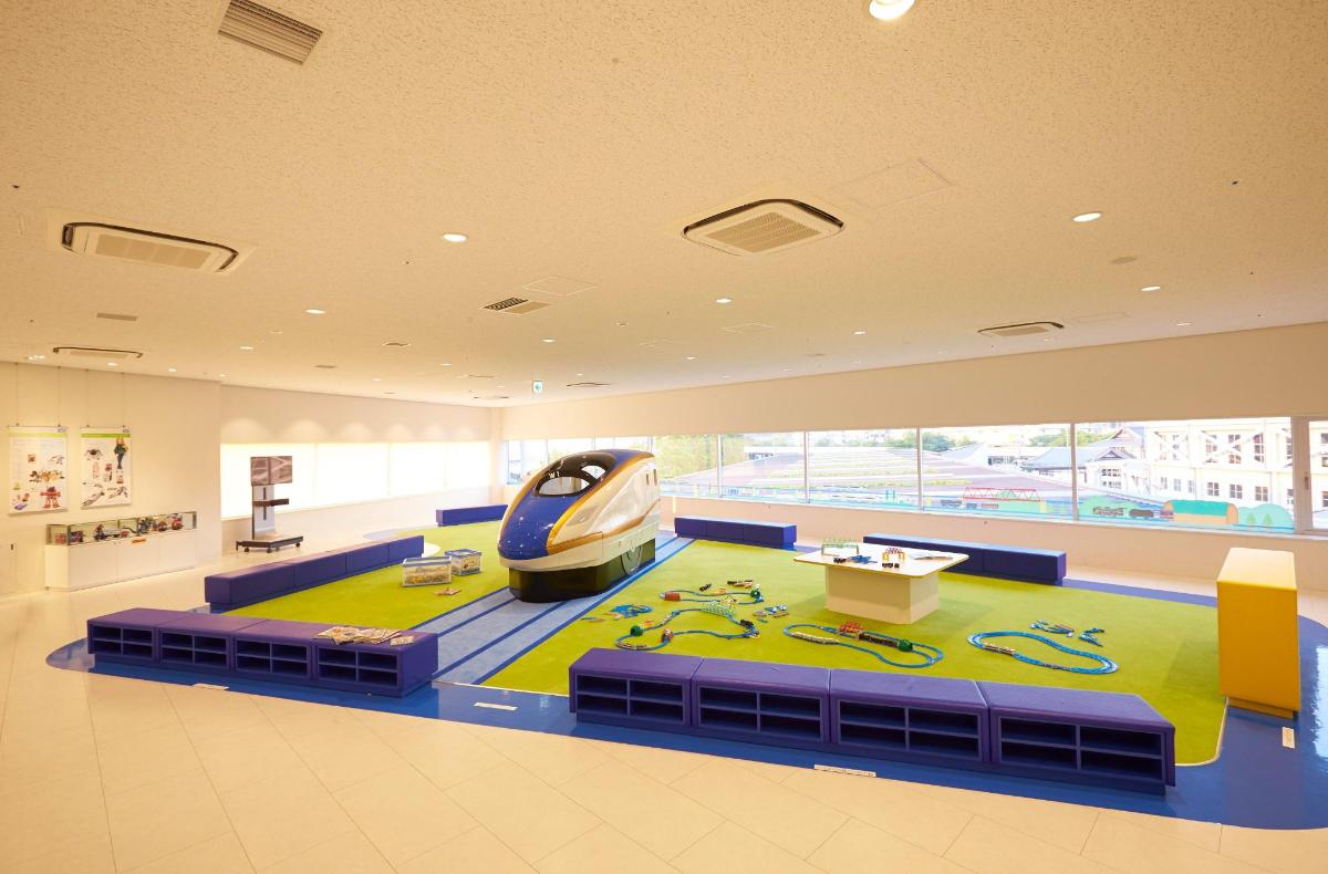 uma sala grande com um trem em um tapete