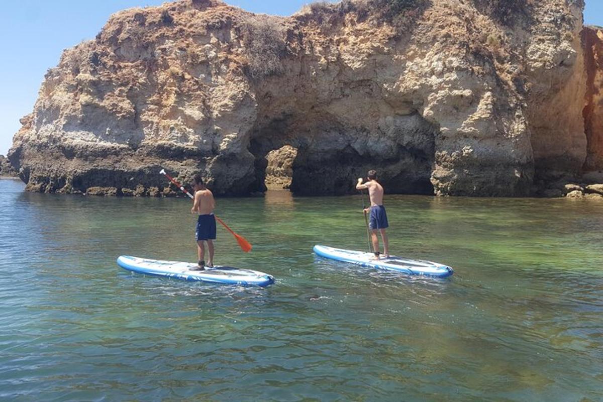 Dva muži stojí na paddleboardech ve vodě