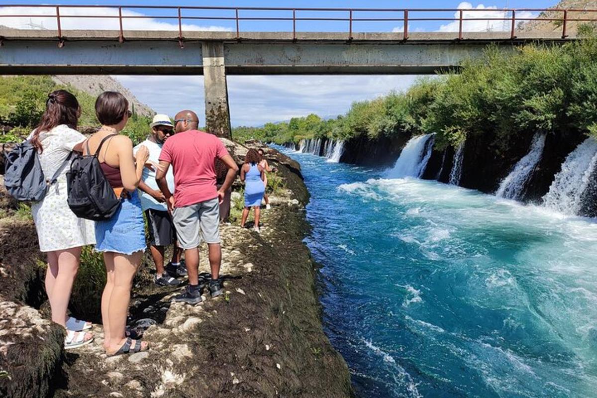 skupina lidí stojící vedle vodopádu