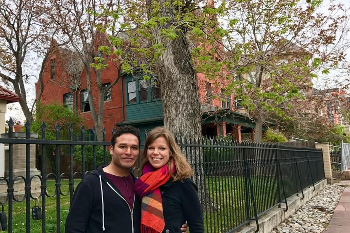 a man and woman standing in front of a house