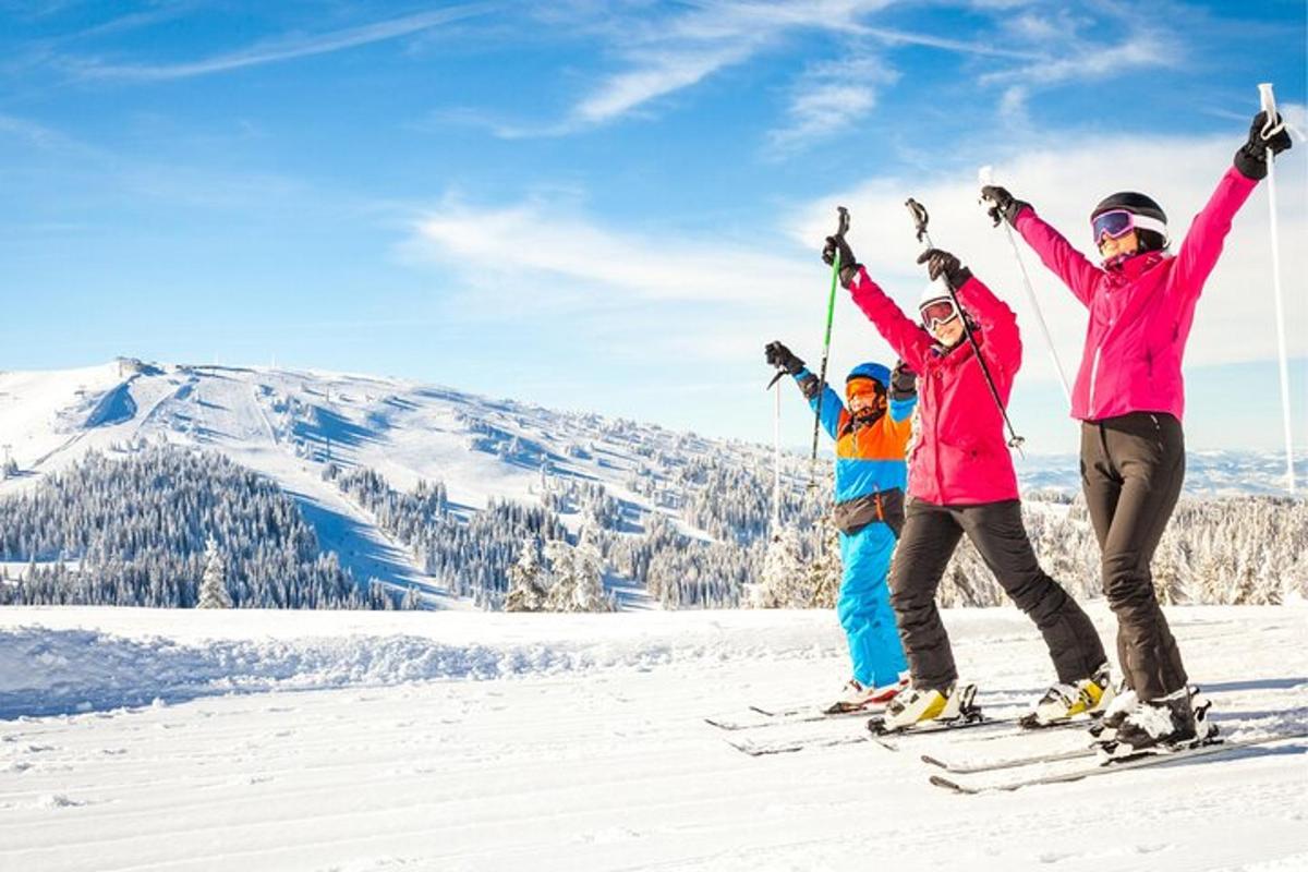 a group of three people standing on top of a ski slope