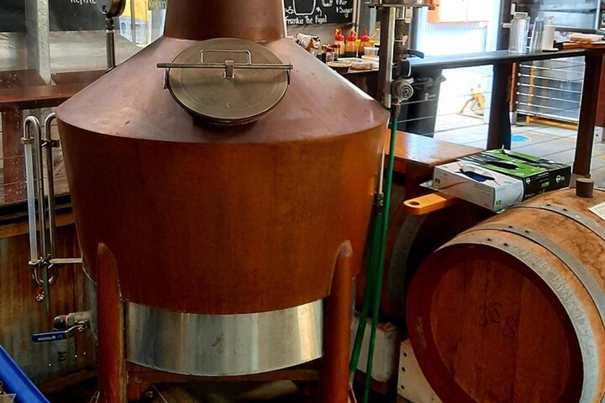 una grande pentola di metallo posta sopra una botte