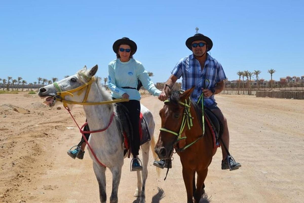twee mensen rijden op paarden in de woestijn