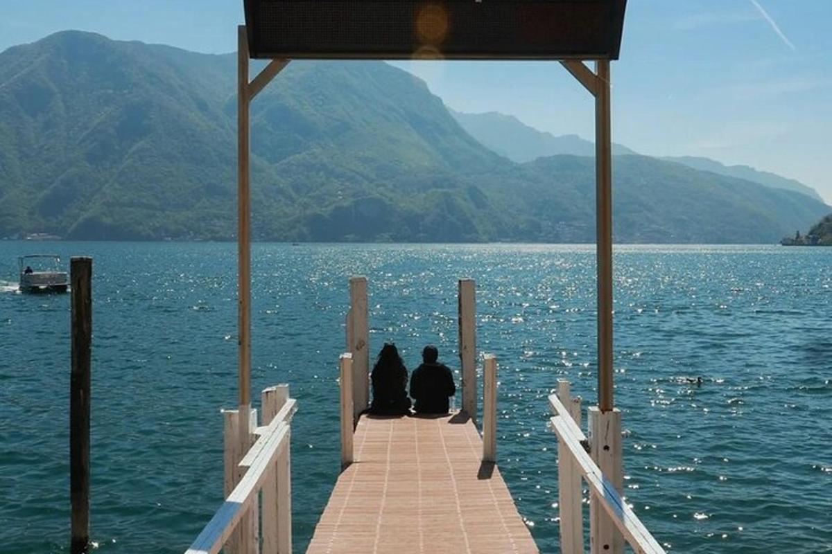 duas pessoas sentadas em um cais na água