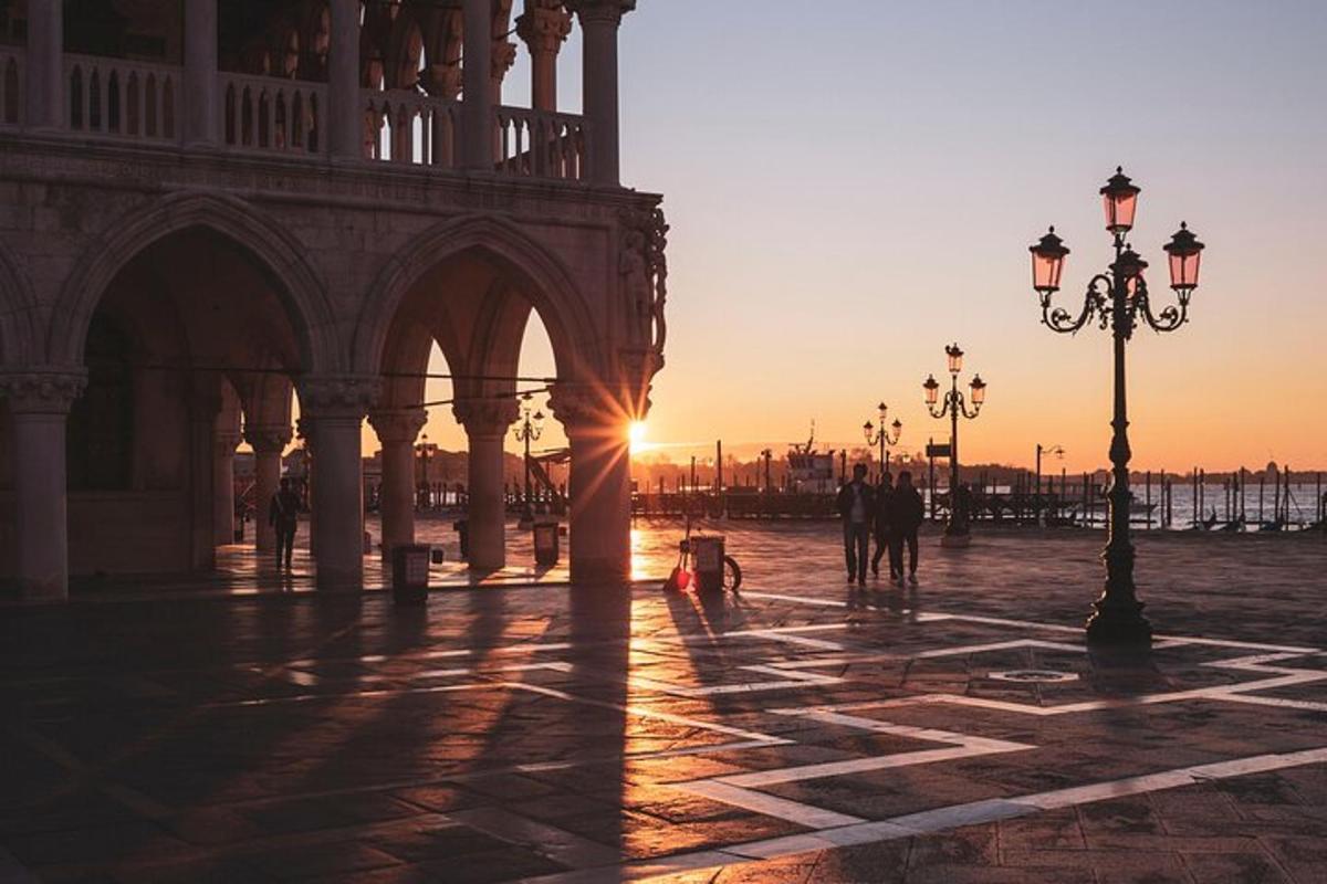 um pôr do sol em uma praça em frente a um prédio